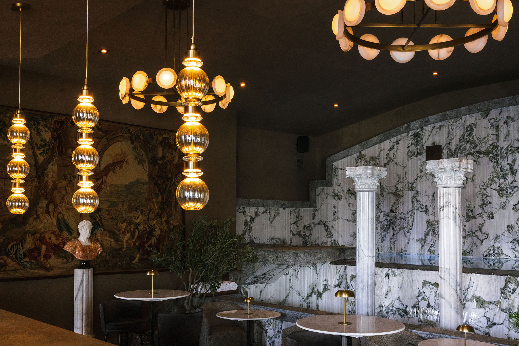 Stylish rooftop bar interior with marble accents, sculptural lighting, and glimpses of the indoor overflow pool at C’est La Vie rooftop lounge in Condado, San Juan.