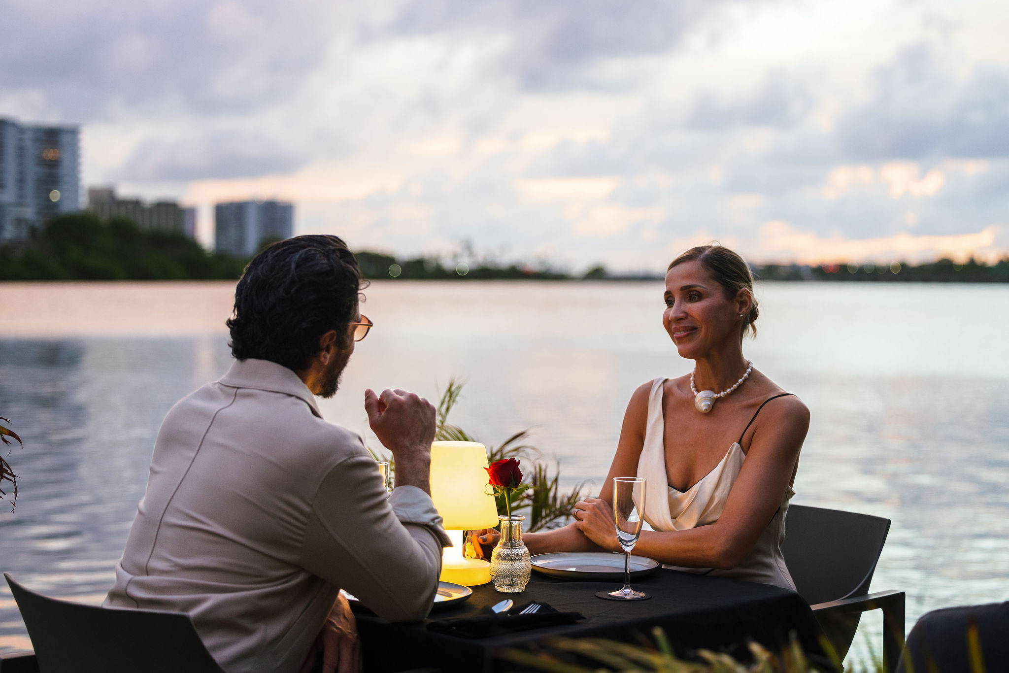 Couple dining on a private floating deck during the Dinner Under the Stars experience at O:live Boutique Hotel in Condado Lagoon, San Juan, Puerto Rico.